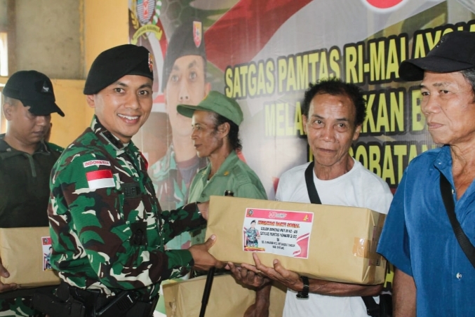 Dansatgas Letkol Kav Alfid Dwi Arisanto menyerahkan bantuan secara simbolis kepada warga perbatasan