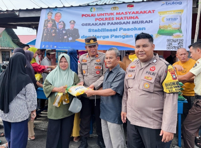 Kapolsek Bunguran Barat Iptu Raja Oloan Purba menyerahkan sekarung beras SPHP kepada warga Sedanau dalam program Gerakan Pangan Murah di Simpang 4.