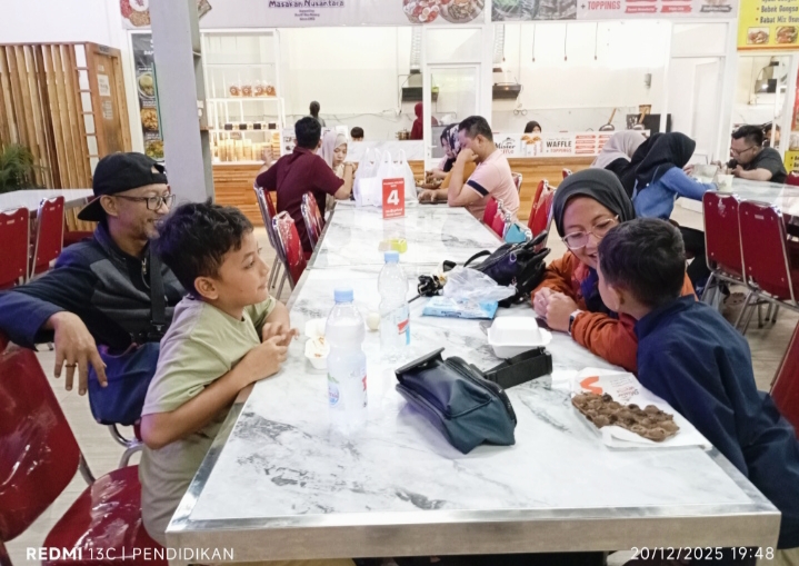Chandra sekeluarga pengunjung asal Kota Tuban ketika di Pusat Kuliner Alun-alun Batu sambil menikmati musik yang dimainkan oleh KPJ