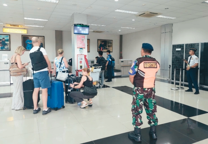 Personel TNI AU dan Avsec berkoordinasi mengamankan area check-in penumpang di Bandara Raden Sadjad Natuna pada periode libur Nataru."