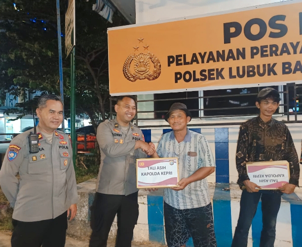 Suasana akrab penyerahan bantuan sosial (tali asih) oleh personel Polresta Barelang kepada masyarakat di Pos Pengamanan Nataru Nagoya Hill.