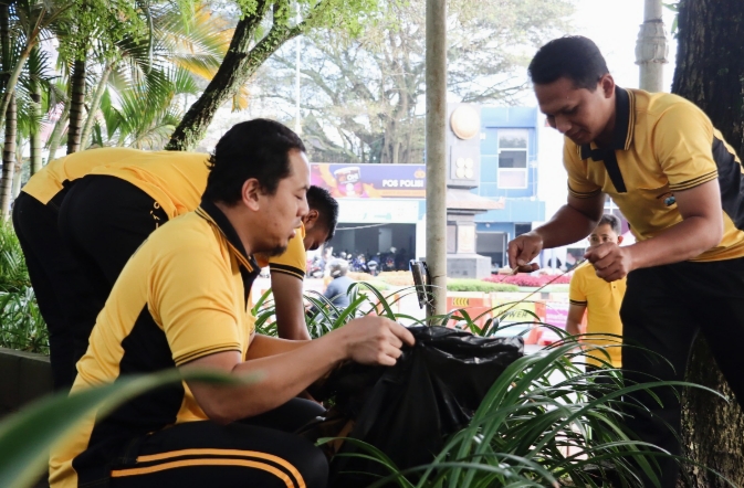 Personel Polres Batu dan pegawai Pemkot Batu bersama-sama membersihkan sampah dan merapikan tanaman di kawasan Alun-Alun Kota Batu.