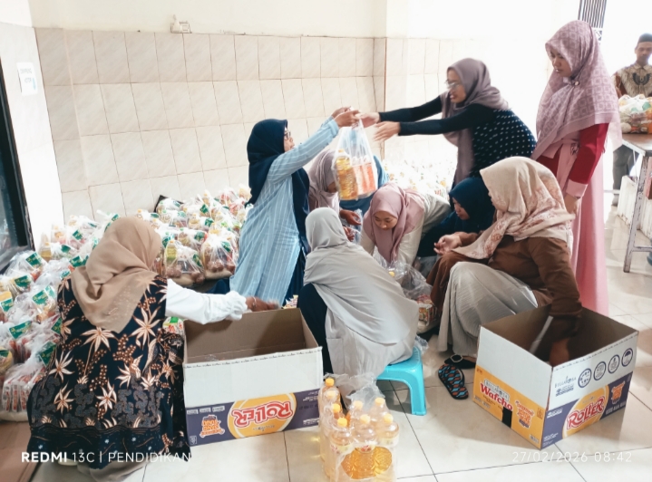 Para guru dengan penuh semangat membungkus dan mempersiapkan paket sembako untuk masyarakat