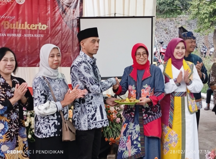 Kepala Desa Bulukerto berjabat tangan dengan Ketua Dekranasda Kota Batu ketika menyerahkan potongan tumpeng secara simbolis