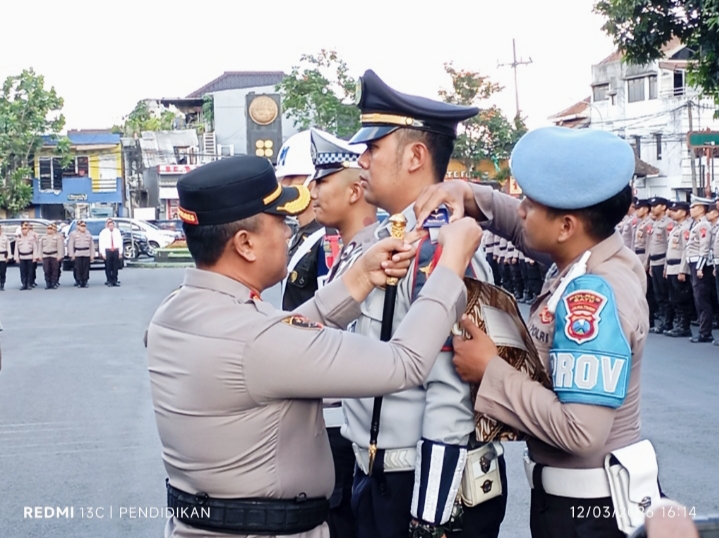 Kapolres Batu ketika penyematan tanda kepada petugas dalam acara apel operasi Ketupat 2026.