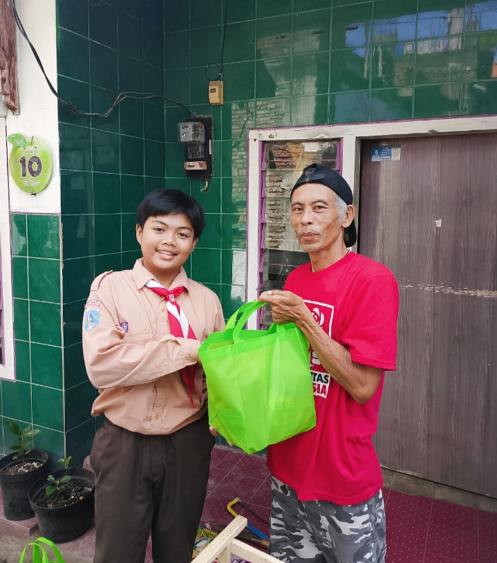 Siswa MI Miftahul Ulum ketika memberikan kepada kakek berupa paket sembako