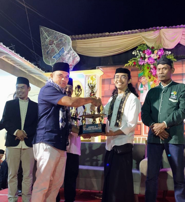 Salah satu juara Gema Takbir ketika menerima piala dari salah satu perwakilan dari pemerintah Desa Sumberjo. 