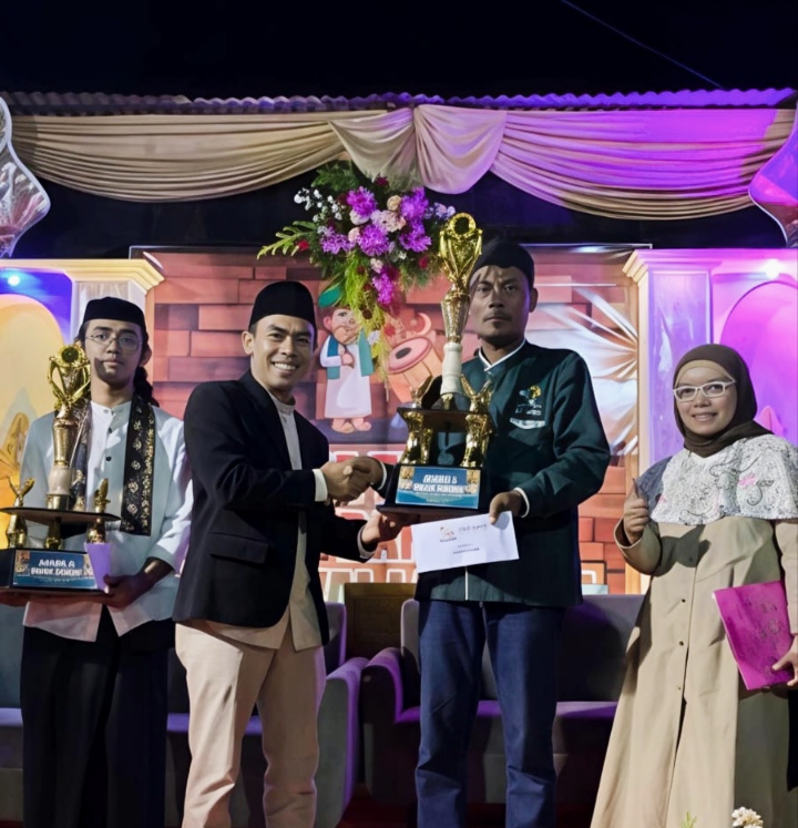 Sekretaris Desa Sumberjo mewakili kepala Desa Sumberjo ketika menyerahkan piala kepada juara Gema Takbir dan Festival Lampion 2026.