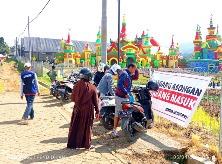 Petugas parkir ketika memberikan pelayanan parkir kendaraan bermotor kepada pengunjung.