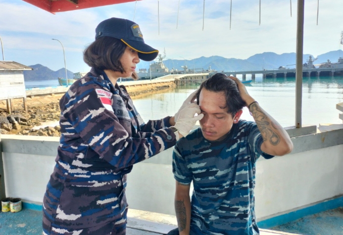 Anggota TNI AL ketika mengobati luka para korban kapal kebaran.