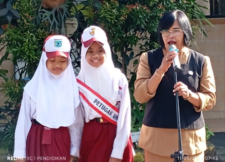 Siswi peraih juara ketika bersama kepala sekolah dihadapan siswa siswi lainya. 