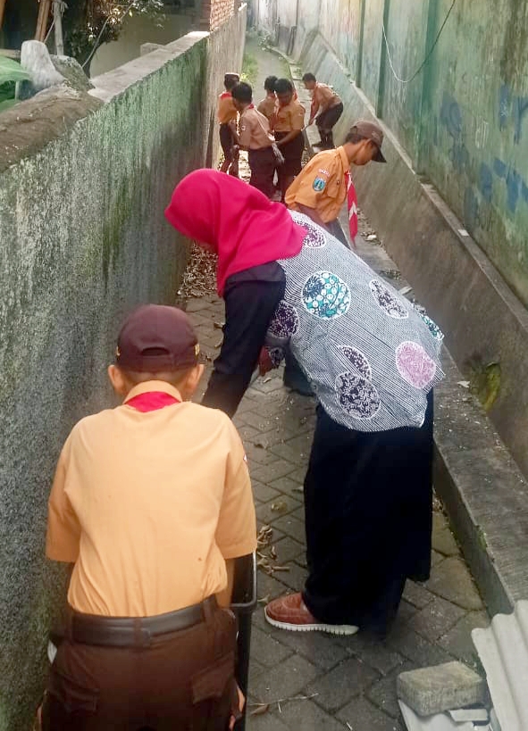 Siswa Siswi bersama guru pembina bersihkan lingkungan area luar sekolah, sadar lingkungan yang bersih. 
