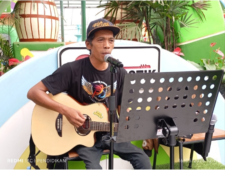 Ketua Power Of Disability, Eko ketika membawakan sebuah lagu lagunya.