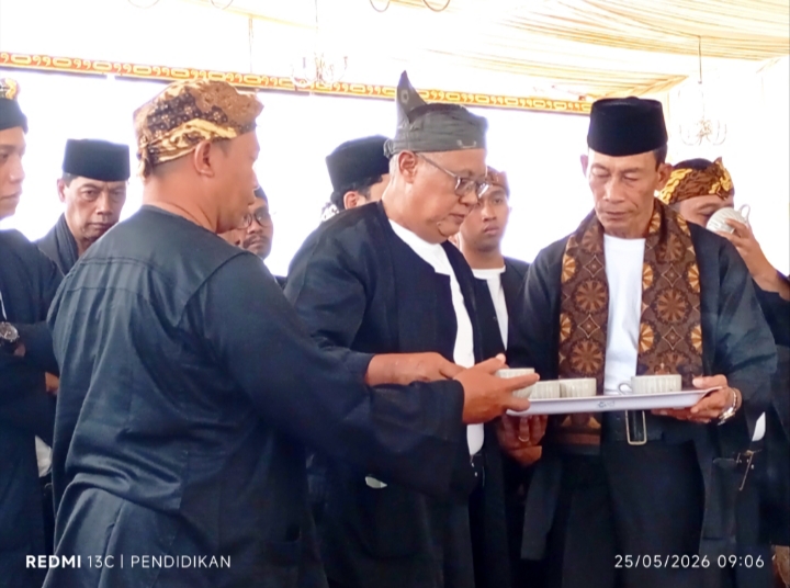 Kepala Desa Oro Oro Ombo, ketika memberikan air ketan hitam kepada seluruh perangkat desa dan masyarakat yang hadir.