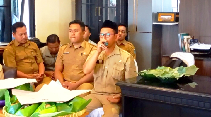 Petugas memimpin doa bersama sama di kantor kepala desa yang baru. 