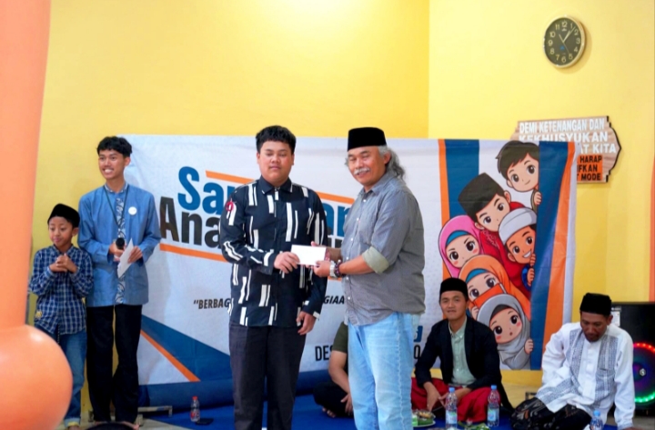 Kepala Desa Tulungrejo, Suliyono ketika memberikan santunan kepada penerima manfaatnya.