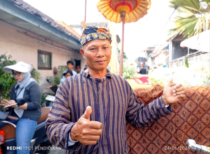 Kepala Dusun Pendem ketika di depan beberapa Tumpeng. 