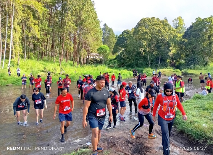 Tampak beberapa peserta melintasi sungai yang merupakan rute wajib dalam Fun Trail Run. 