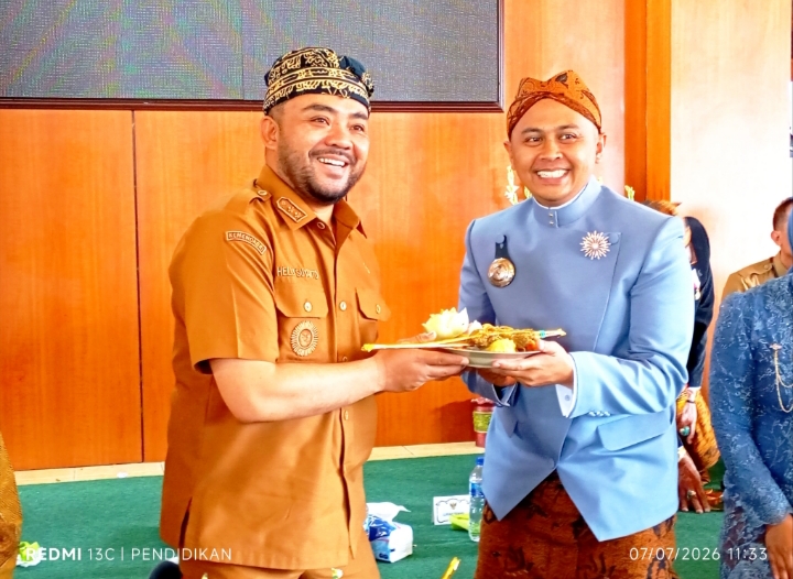Wakil Wali Kota Batu ketika menyerahkan potongan nasi tumpeng kepada kepala Desa Kelurahan Temas.