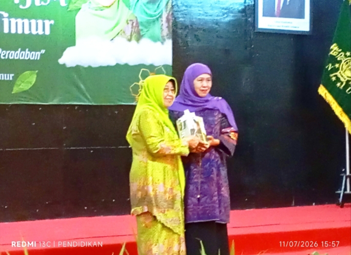 Ketua DPW Muslimat Jawa Timur ketika memberikan apresiasinya berupa buku kepada Ketua Umum Muslimat Jawa Timur.