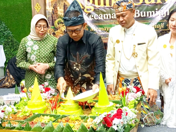 Wali Kota Batu, H. Nurochman, S.H., M. H ketika prosesi pemotongan tumpeng yang diberikan kepada Camat Bumiaji. 