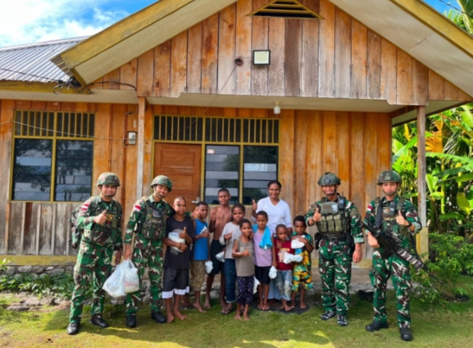 Tampak TNI setelah membagikan kitab kepada warga masyarakat.