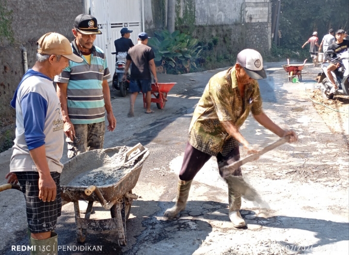 Tampak dengan semangatnya warga masyarakat melakukan pengecoran jalan yang berlubang.