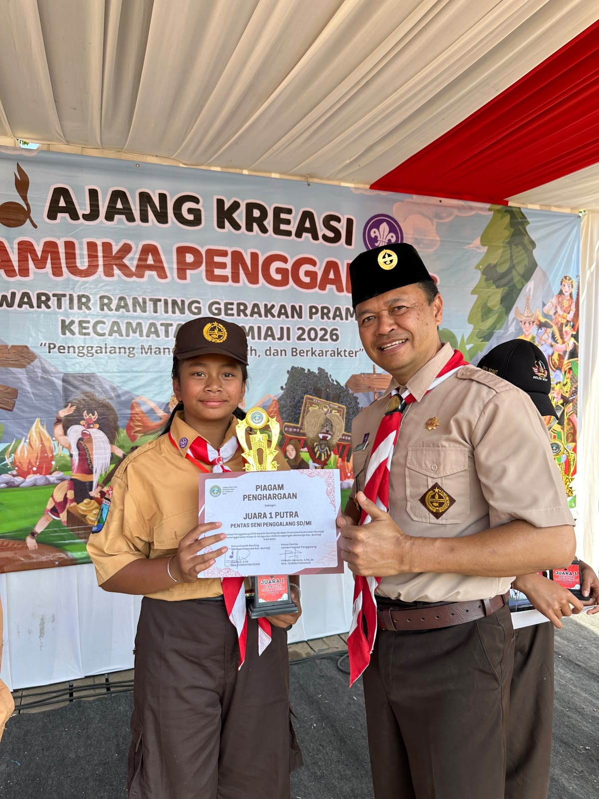 Tampak Ketika Camat Bumiaji memberikan apresiasi kepada salah satu juara lomba di kegiatan pramuka.