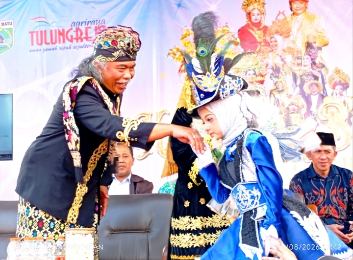 Kepala Desa Tulungrejo ketika menerima salam hormat dari salah satu peserta Taman Kanak-kanak Kanak. 