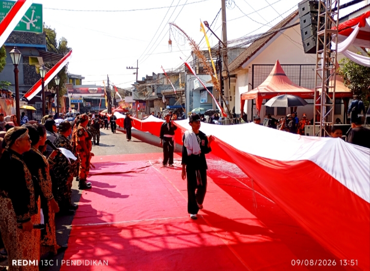 Tampak anggota PSHT melewati panggung penghormatan dengan membawa bendera merah putih 100 meter