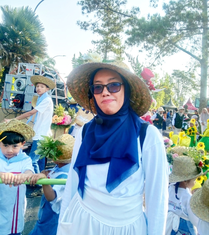 Salah satu guru TK antusias bersama anak didiknya mengikuti Karnaval gebyar PAUD.
