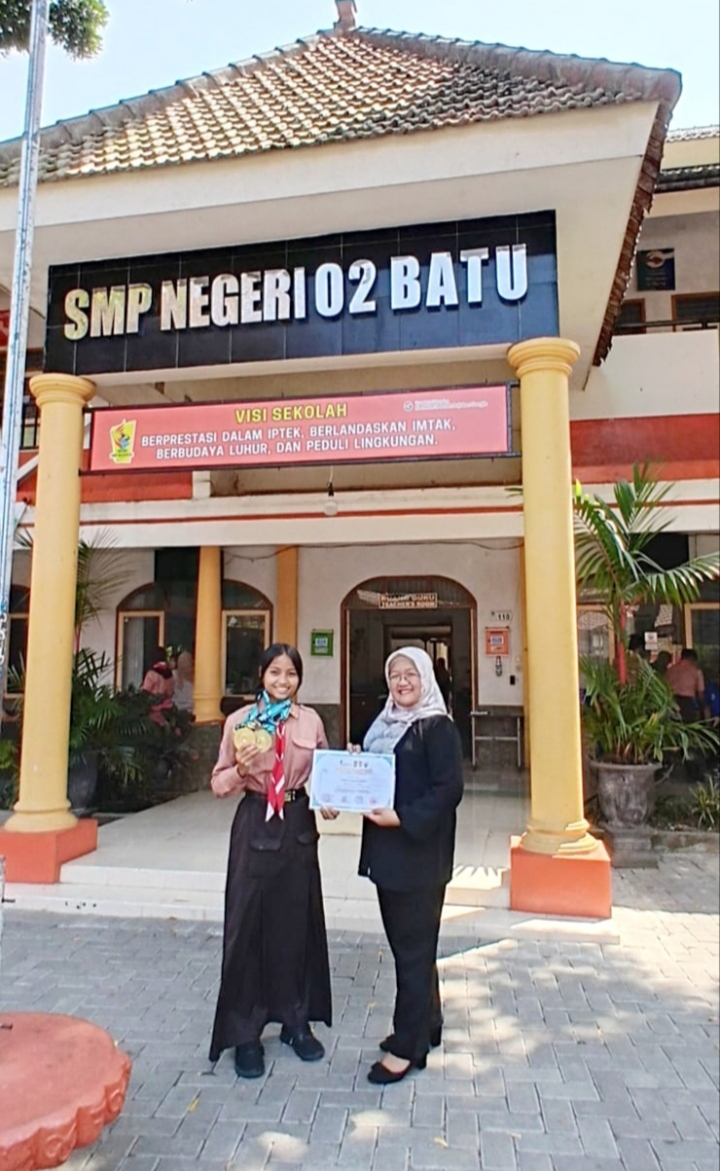 Tampak Wakil Kepala Sekolah SMPN 02 Batu ketika bersama siswinya yang memperoleh medali emas pada Kejuaraan Karate Internasional di Yogyakarta. 