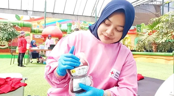 Tampak petugas ketika menunjukan satu kantong darah hasil donor dari peserta.