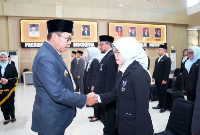 Tampak Wali Kota Batu berjabat tangan kepada salah satu penerima Satya Lencana. 