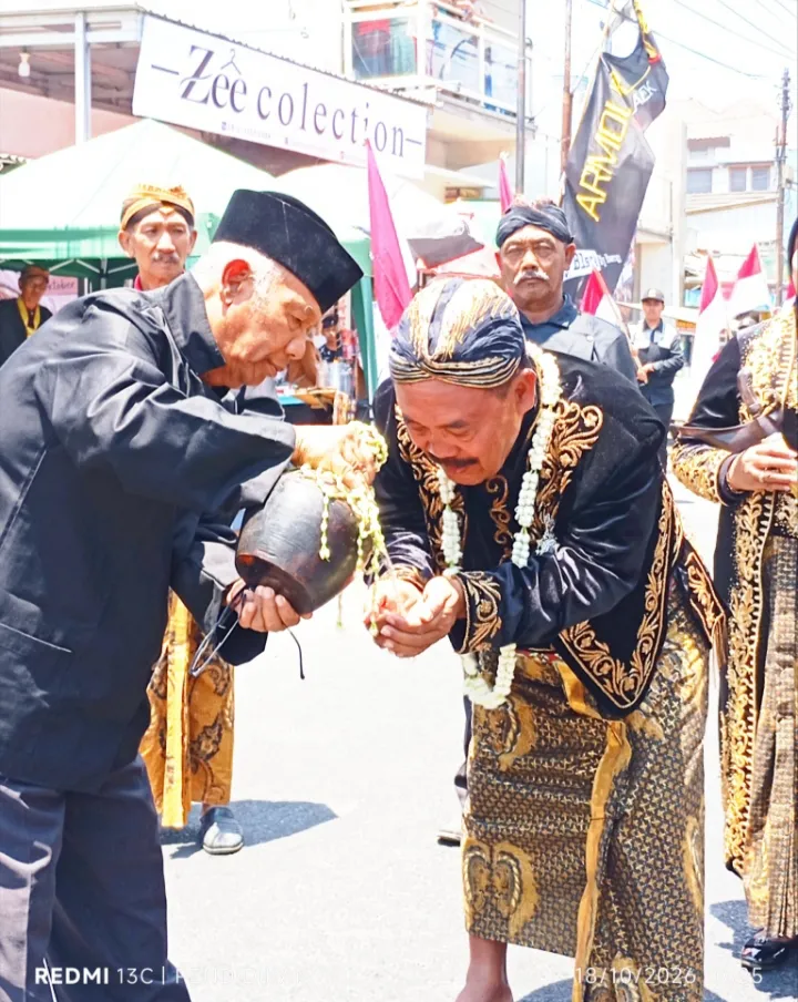 Tampak kepala desa menerima air dari kendi untuk di basuhkan ke muka, rangkaian ritual sebelum masuk di barusan Kerispora