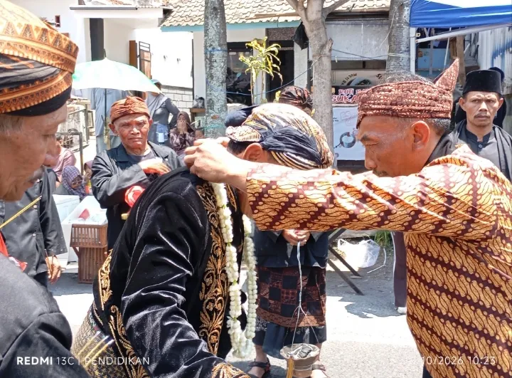 Tampak Prosesi yang dilakukan oleh anggota Lembaga Adat didalam menyambut kedatangan kepala desa di panggung kehormatan. 
